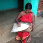 woman picking through a bushel of grains