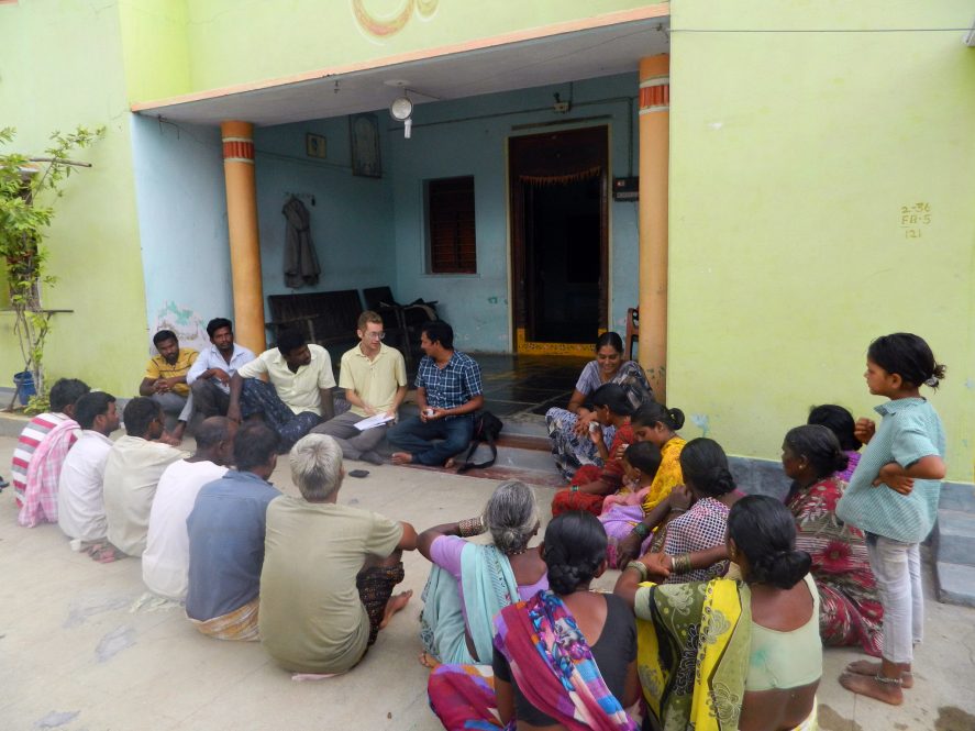 Anthony Wenndt sitting and talking with a group of men and women