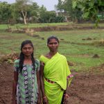A mother and daughter standing on farmland