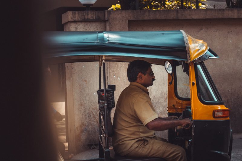 a man sitting in a motorized rickshaw