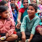 Children sitting and eating sweet potatoes