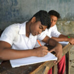 Male students writing in school