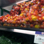 Tomatoes in plastic bags on a supermarket shelf