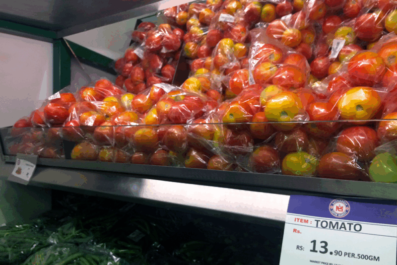 Tomatoes in plastic bags on a supermarket shelf
