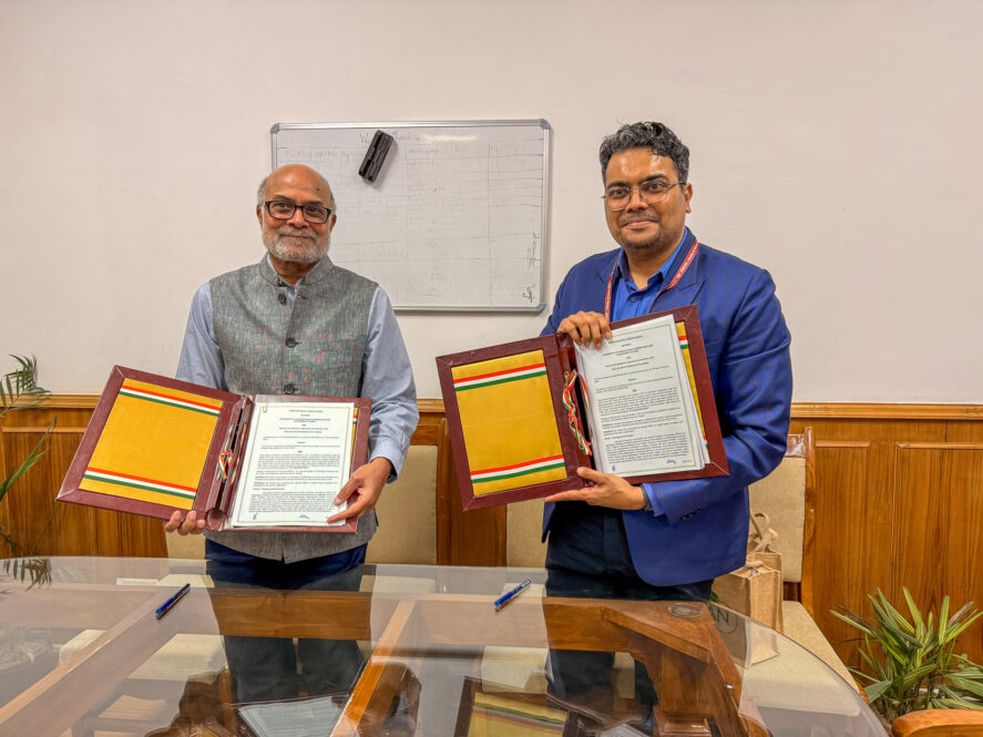 Prabhu Pingali and Chinmay Gotmare posing with signed copies of a memorandum of understanding between TCI and the Ministry of Agriculture